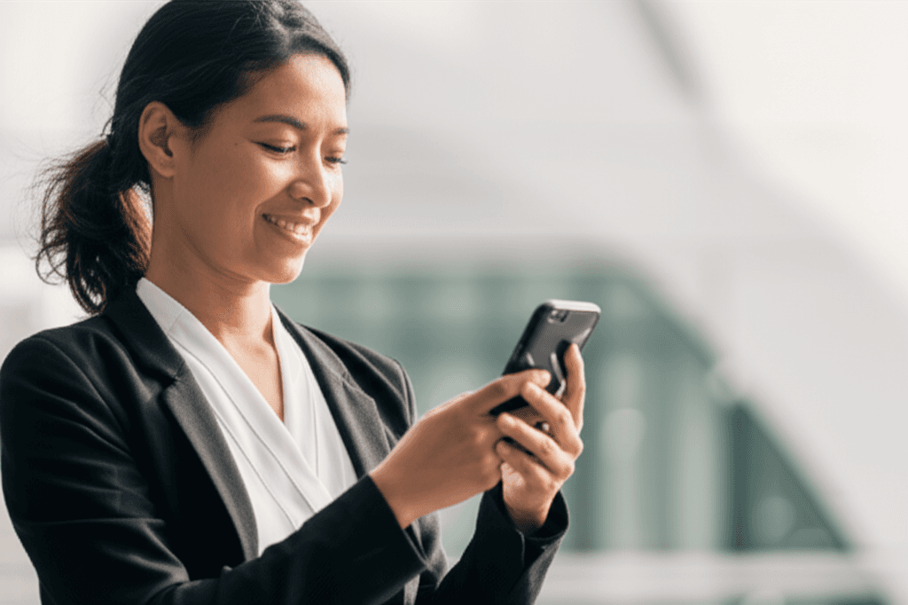 Smiling woman in yellow sweater holding phone